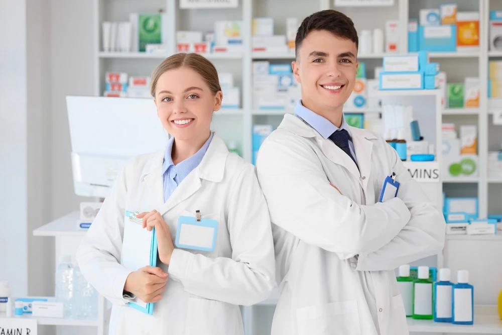 Foto ilustrativa do artigo sobre atendimentos em serviços de saúde: dois farmacêuticos sorrindo.